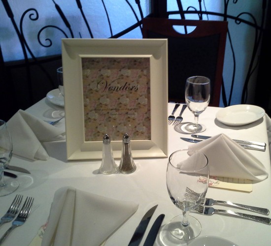 Elegant table setting with framed vendors sign, ready for a banquet