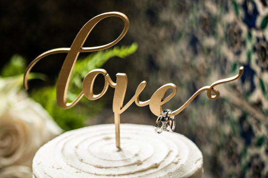 Elegant golden love cake topper with rings for a wedding