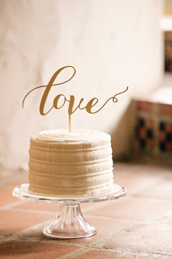 Wedding cake with Love topper on a glass cake stand