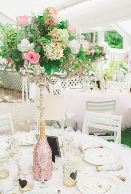 Outdoor wedding table with pink flowers and champagne
