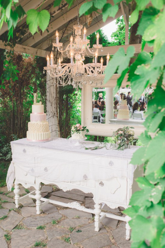 Elegant wedding cake under chandelier outdoor venue