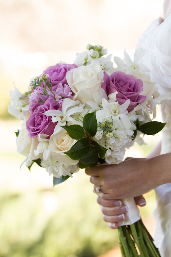 Bride holding a beautiful bouquet of purple and white flowers
