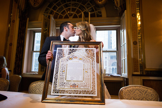 Couple kissing with wedding certificate, celebrating their marriage
