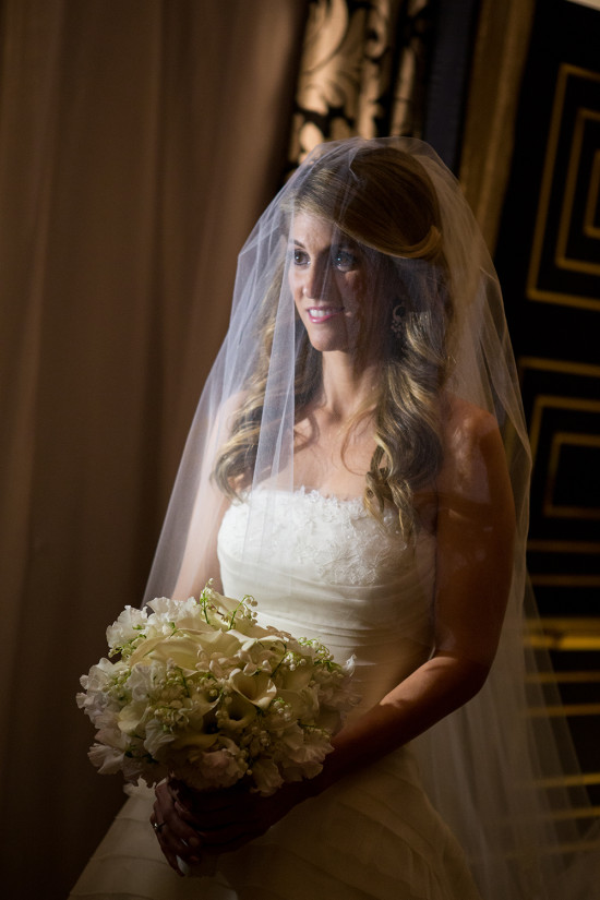 Bride in a wedding dress with a beautiful bouquet smiling coyly