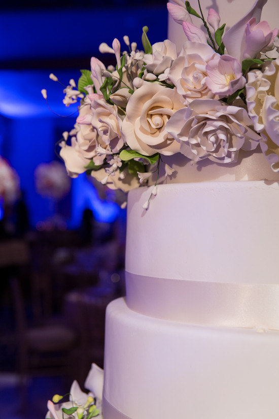 Elegant white wedding cake with floral decorations close up
