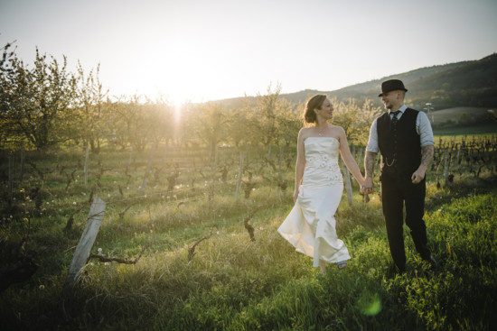 Bride and groom hold hands during wedding ceremony in nature