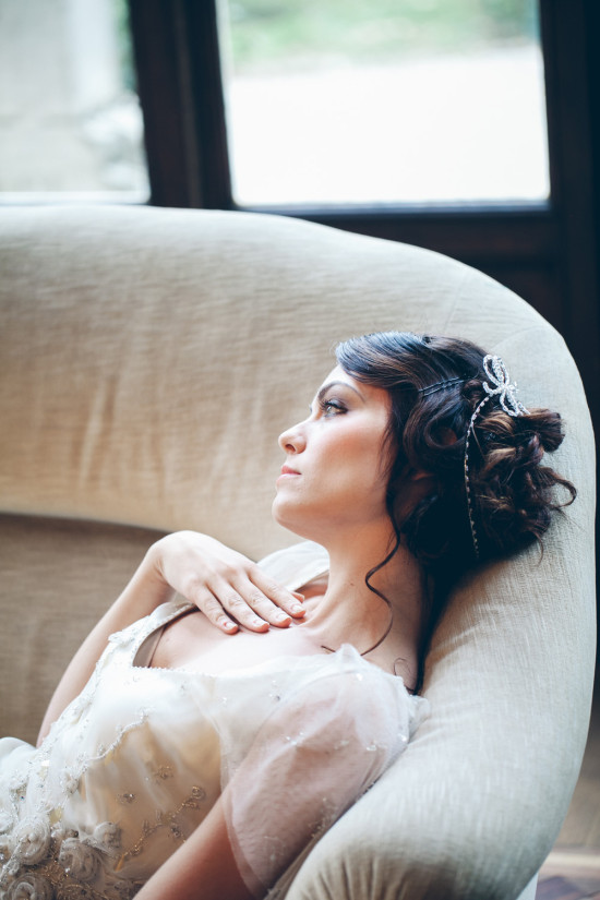 Pensive bride rests in an armchair wedding day portrait