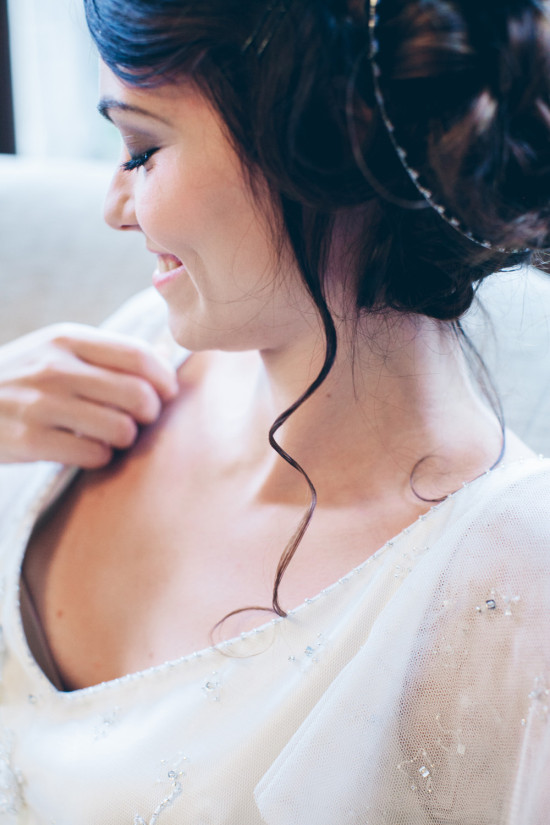 Smiling bride adjusts her dress before the wedding ceremony