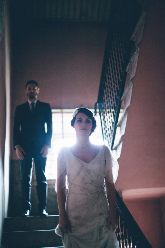 Bride and groom pose on aged stairway after wedding