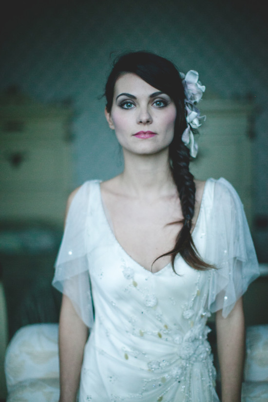 Brunette bride with flower in hair in a white gown