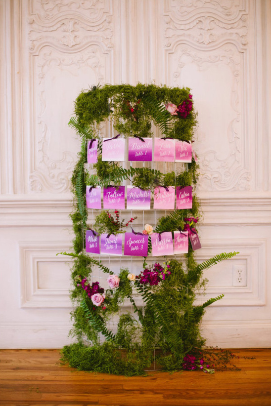 purple dip dyed escort cards on moss covered stand