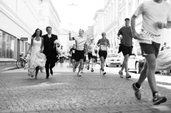Bride and groom running marathon in wedding attire