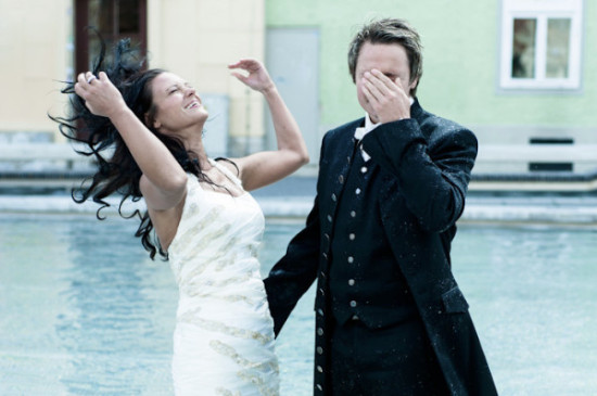 Bride celebrates in the rain, groom shields eyes on wedding day
