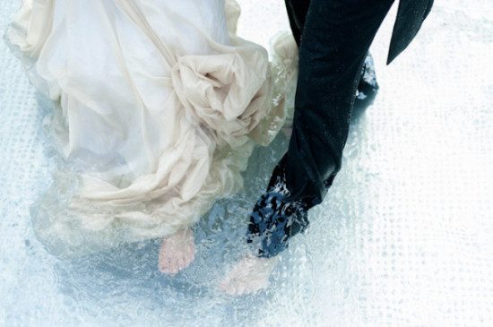 Bride and groom standing in water on a wedding day