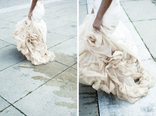 Bride walking with wedding dress on wet pavement