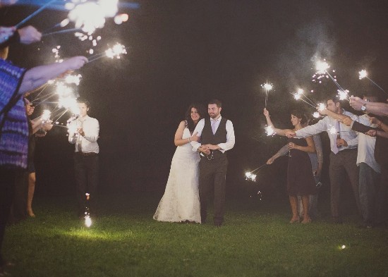 Bride and groom walking through sparklers on their wedding night