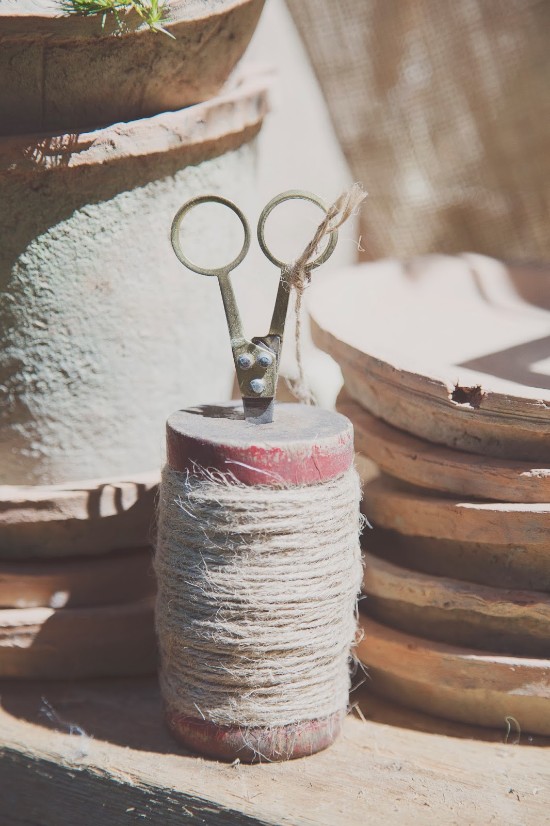 Vintage twine spool with scissors on a wooden surface, rustic charm