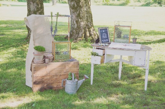 Rustic wedding decor with greenery and a vintage desk on the lawn