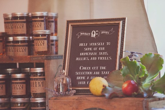 Jars of homemade jams, jellies, and pickles with a charming chalkboard sign