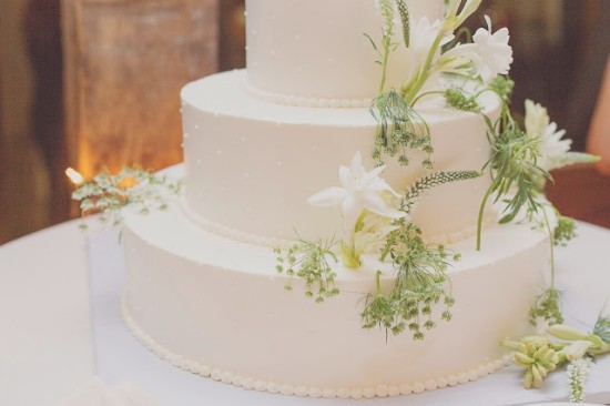 Elegant three-tiered wedding cake decorated with white flowers