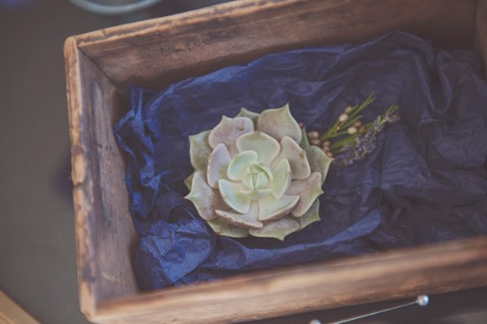 Succulent arrangement in a rustic wooden box with floral accents