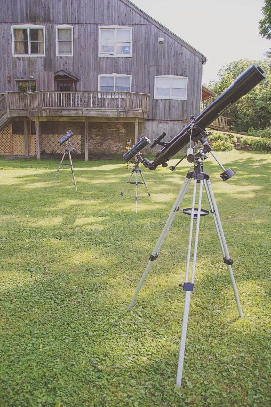 Telescopes set up in a backyard for star gazing on a sunny day