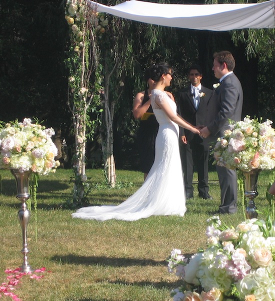 Elegant outdoor wedding ceremony with couple holding hands