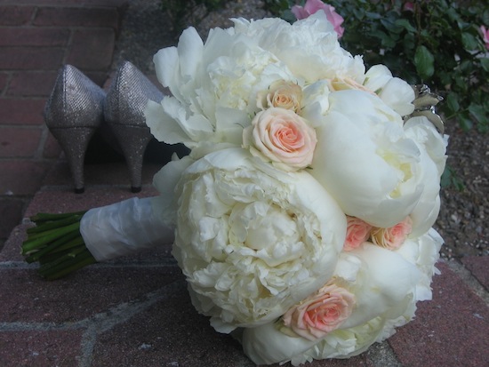 Elegant bridal bouquet with peonies, roses, and sparkly heels