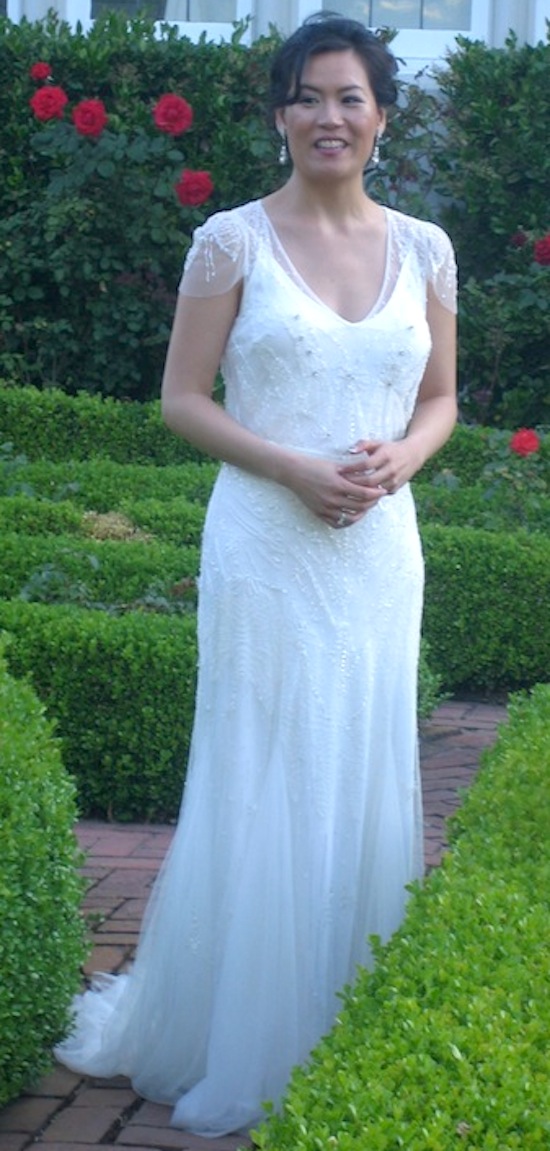 Bride in elegant wedding dress smiles in a garden setting