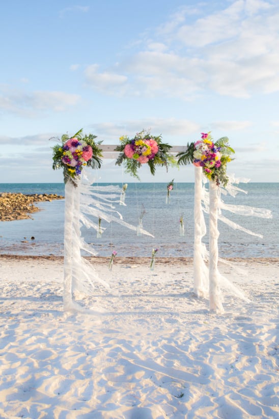 floral and ribbon wrapped wedding arch