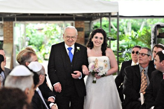 Bride walks down the aisle with her father at a wedding ceremony