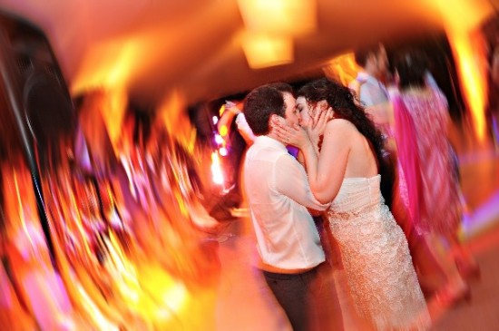 Newlyweds share a passionate kiss during a wedding reception dance