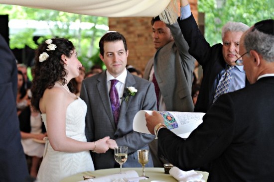 Jewish wedding ceremony with bride and groom under a chuppah