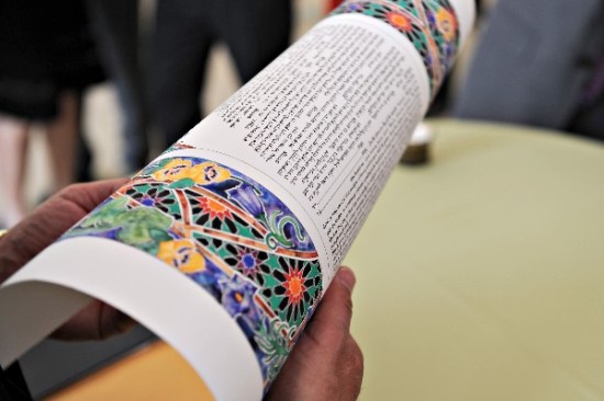 Close up of a decorative Torah scroll being held by a person