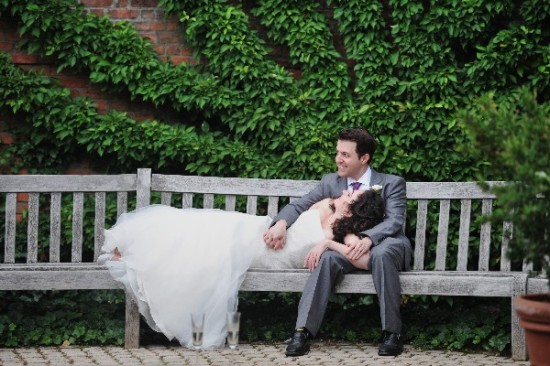 Newlyweds enjoying a moment together on a wooden bench after wedding