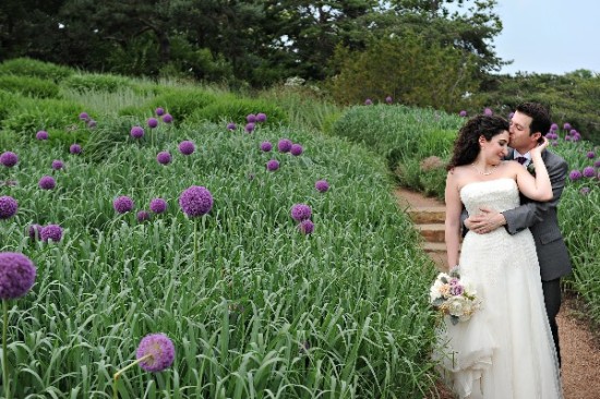 Newlyweds embrace among vibrant flowers in a garden setting