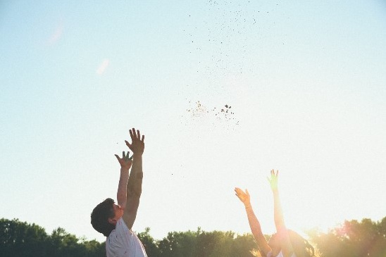 People with arms raised and throwing soil to the sky