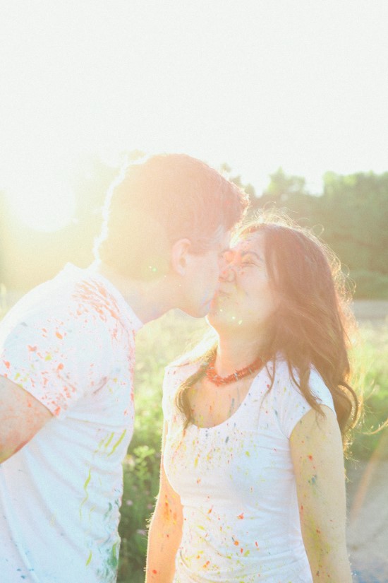 Couple sharing a kiss during a colorful Holi festival celebration