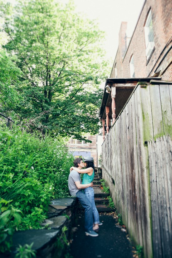 Couple sharing a romantic kiss in a green alley, perfect moment