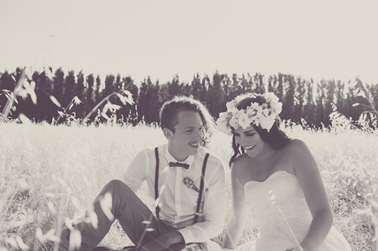 Bride and groom smiling in a sunny field wedding photo