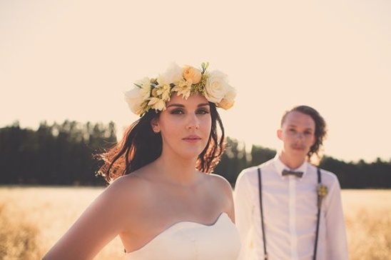 Bride in flower crown with groom suspenders outdoors