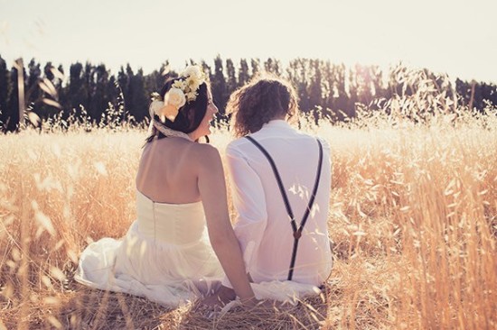 Bride and groom sitting in a sunlit wheat field