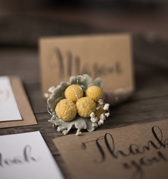 Yellow Craspedia boutonniere with wedding stationery