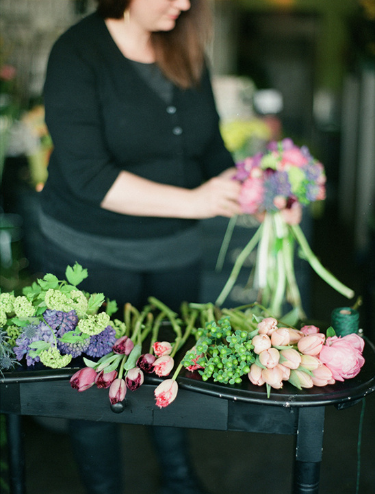 Florist arranging a vibrant bouquet with fresh tulips and greenery