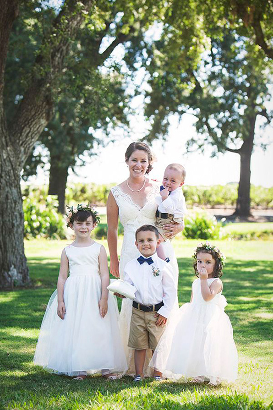 happy bride with the flower girls and ring bearers
