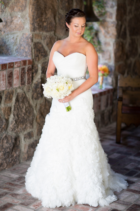 Beautiful bride with white bouquet in strapless gown