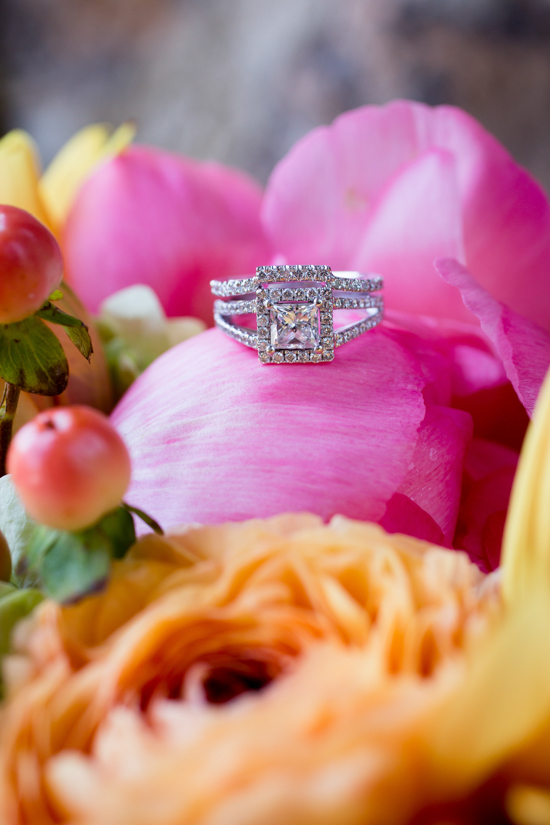 Diamond engagement ring resting on colorful flower petals