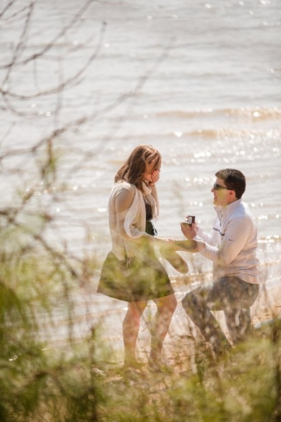 Man proposing to woman by the water, happy moment