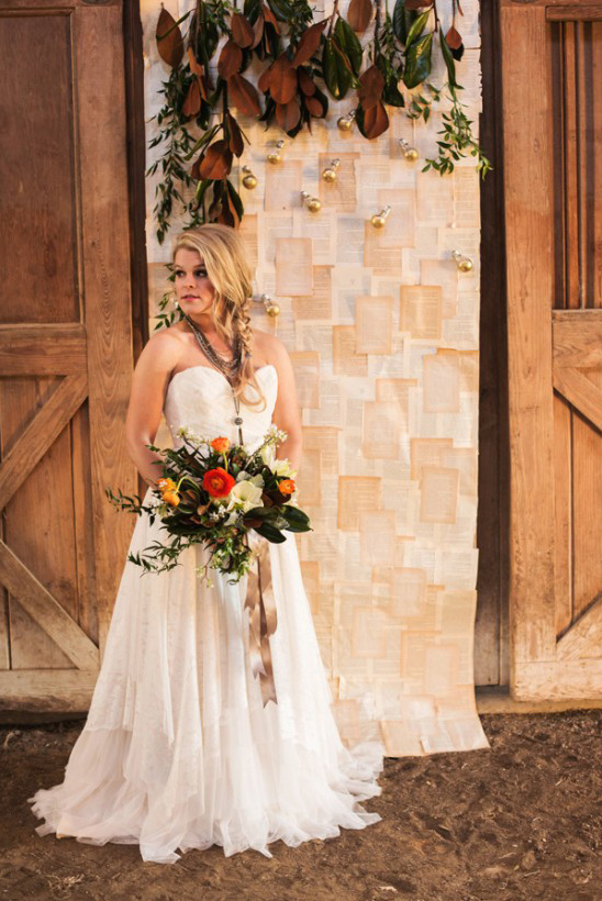 Boho bride in lace gown with bouquet at rustic wedding