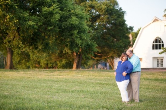 Couple embracing in front of a white barn outdoors
